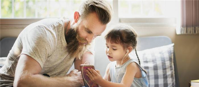 Vater und Tochter schauen auf das Telefon