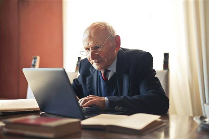 Älterer Mann arbeitet an seinem Laptop