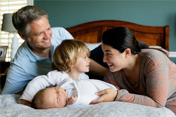 Eltern und Kind auf dem Bett liegend