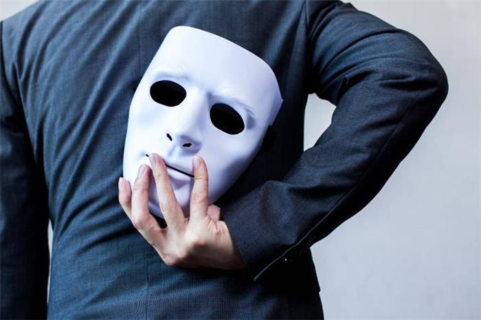 Der Mann hält die Maske aufrecht