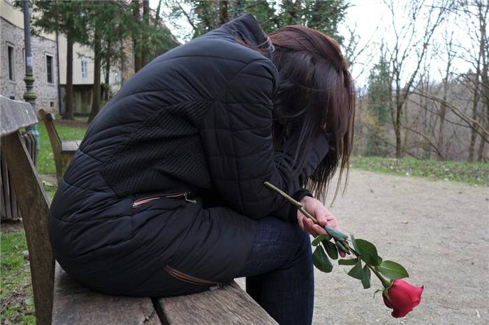 Weinendes Mädchen auf einer Bank