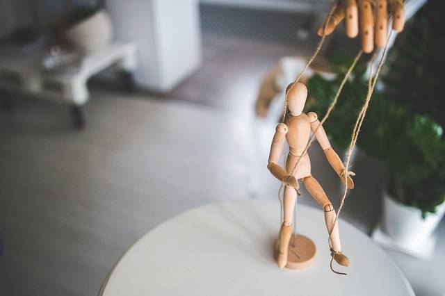 Eine Puppe erliegt der Manipulation