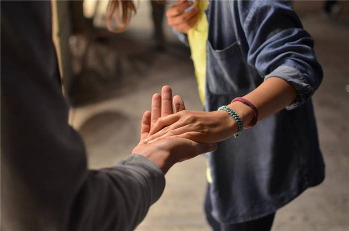 Mann hebt die Hand, um eine andere Person zu unterstützen