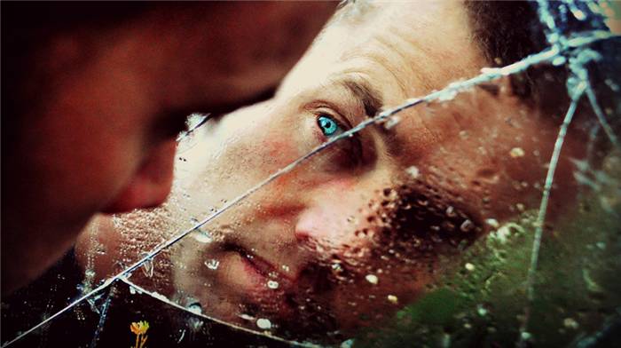 Das Gesicht eines Mannes hinter zerbrochenem Glas