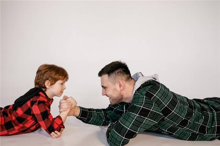 Vater und Sohn konkurrieren mit den Armen des jeweils anderen