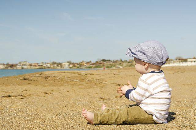 Der Junge, der im Sand sitzt