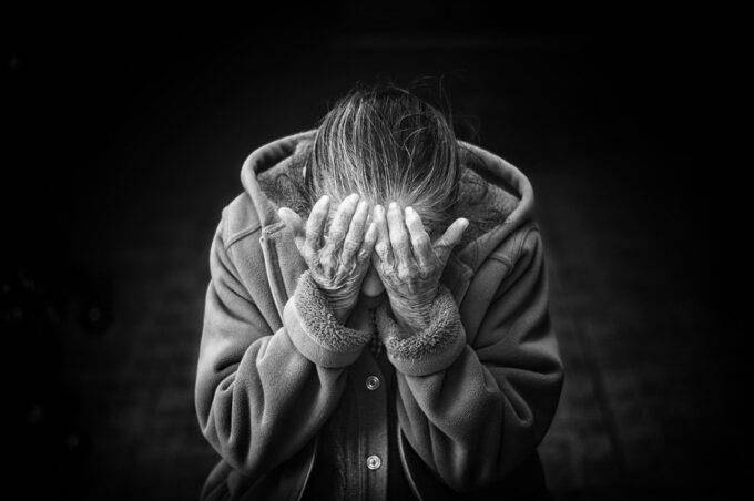 Eine ältere Frau trauert über den Tod ihres Mannes