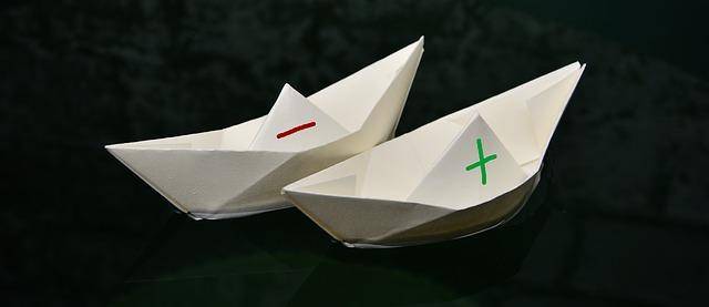 Papierschiffe mit Plus und Minus