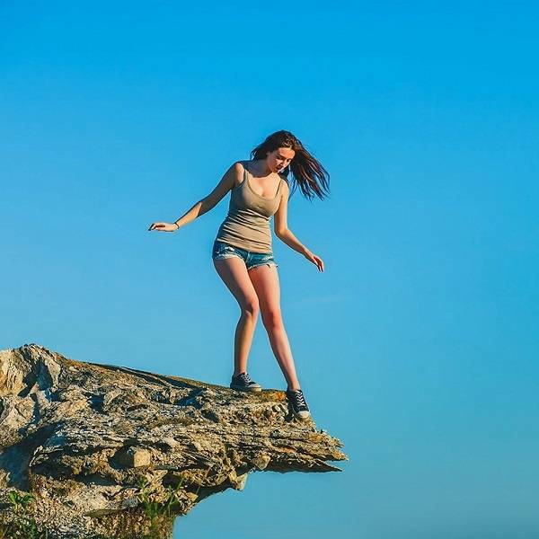 Das Bild zeigt ein Mädchen am Rande einer Klippe